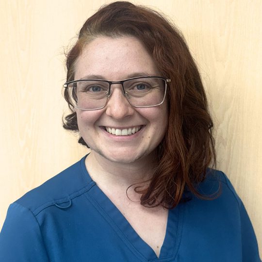 Kestyn wearing blue scrubs and smiling