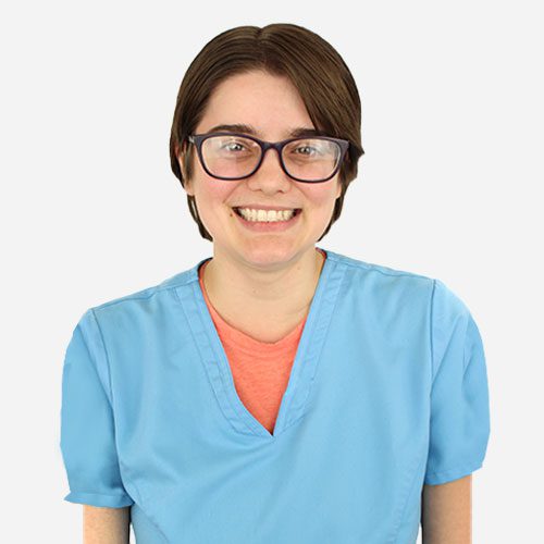Morgan wearing blue scrubs and smiling