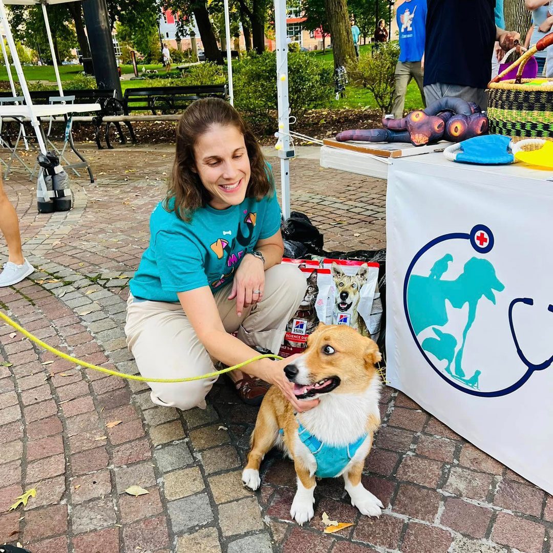 veterinarian petting dog at community event in the park