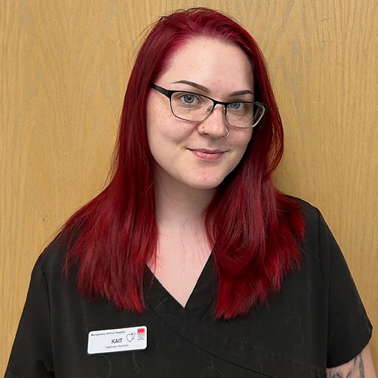 Kait wearing black scrubs and smiling
